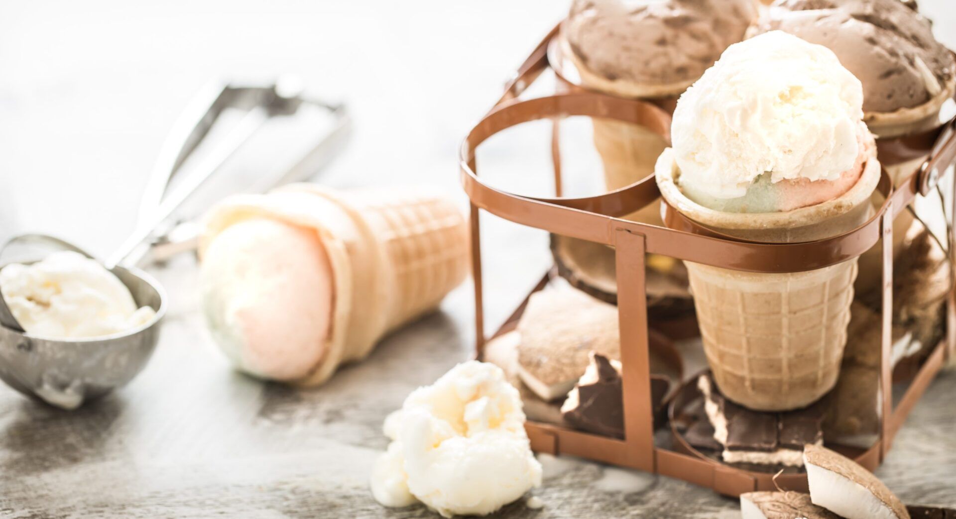 different ice cream in a cone stands in a beautiful stand on a wooden light background, a concept of summer sweets and ice cream